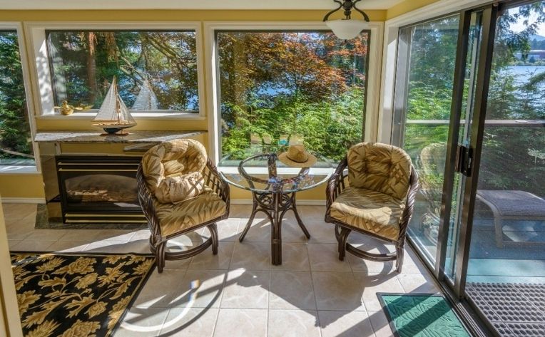 Sunroom with yellow accent chairs and a centre table